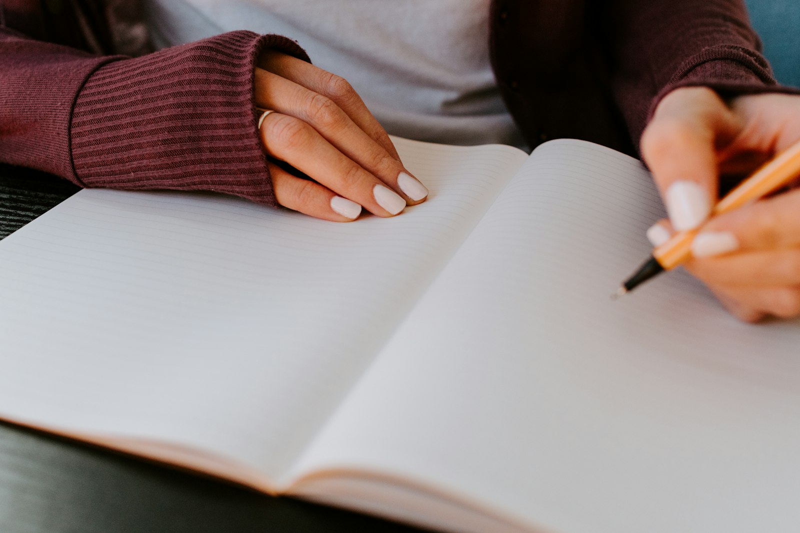 Hands writing in a notebook during a quiet moment of emotional reflection