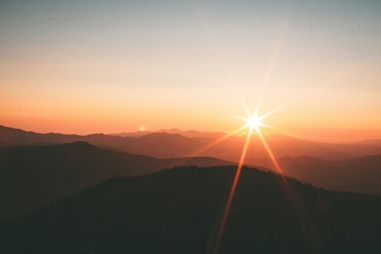 A quiet mountain landscape beneath a soft sunrise